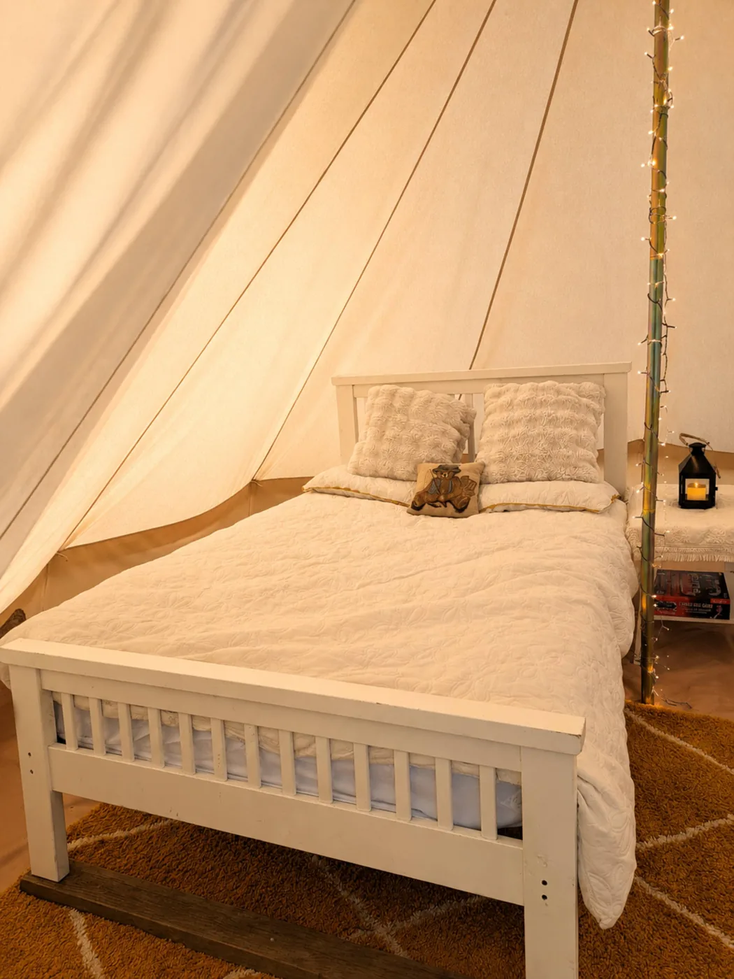 Inside the Bell Tent: a comfortable double bed made up with fresh bedding under the canvas