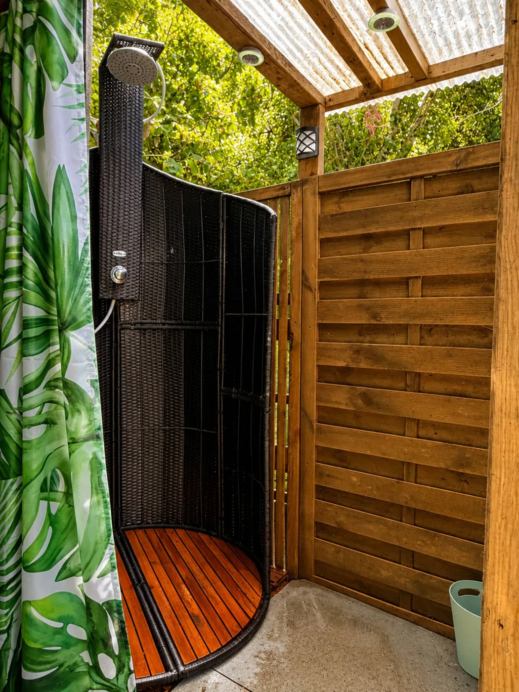 The hot outdoor shower with a wooden floor, tucked among the trees