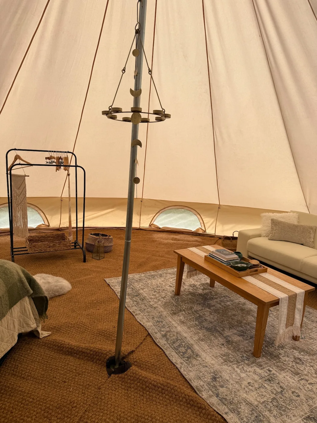 A wide view inside the Family Tent with sofa, table and hanging lantern