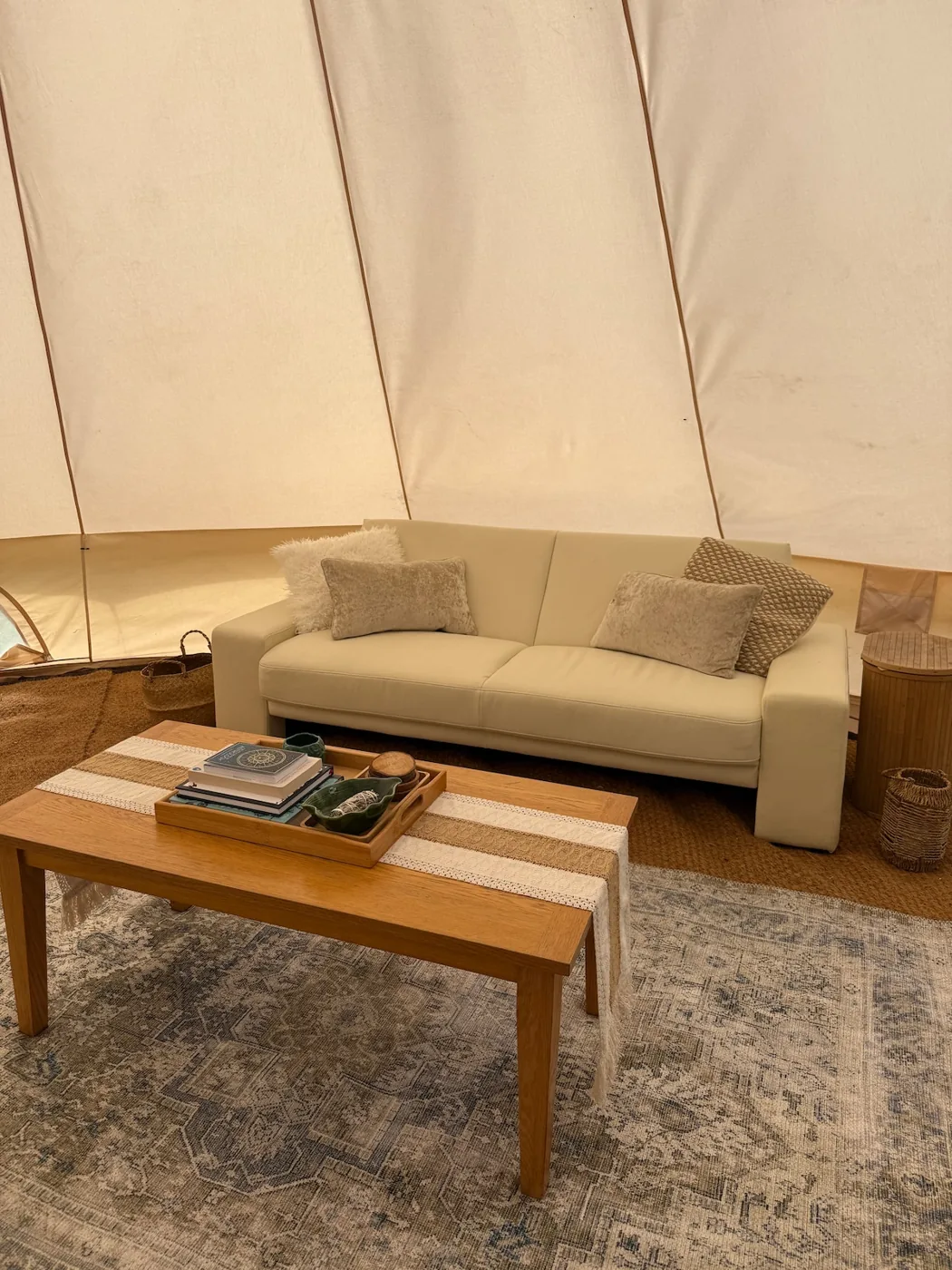 Inside the Family Tent: a sofa and coffee table with books on a woven rug