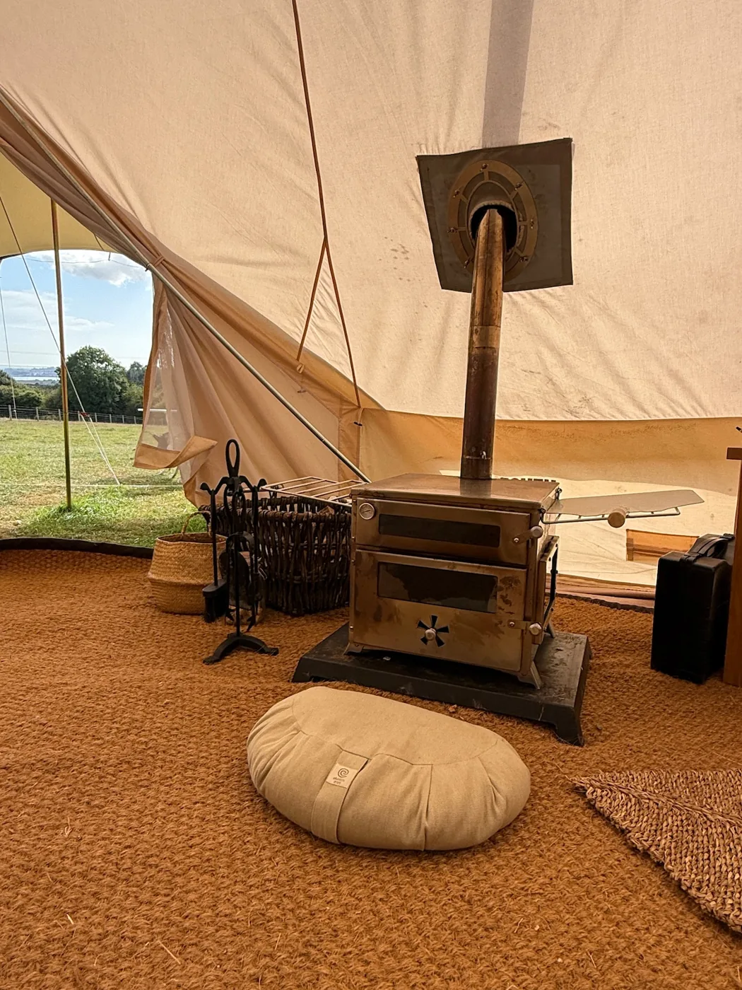 The wood burner and meditation cushion inside the Family Tent